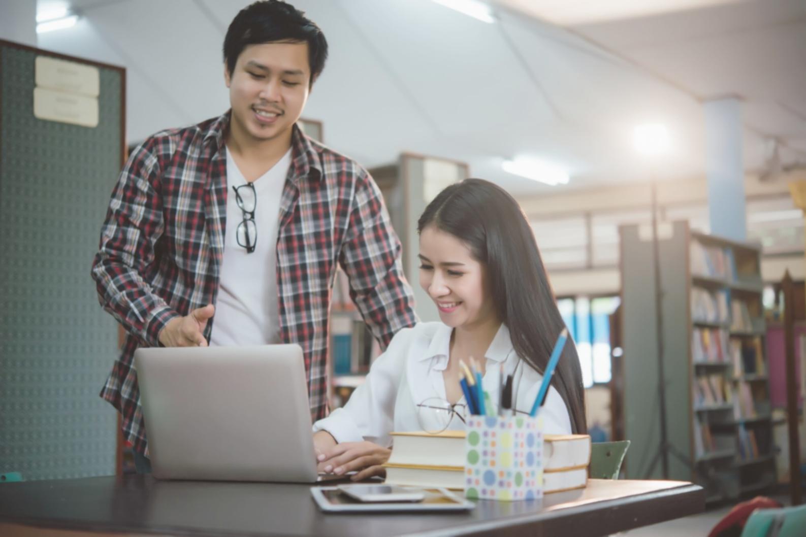 Professional analyzing financial documents with multiple charts and graphs displayed on computer screens